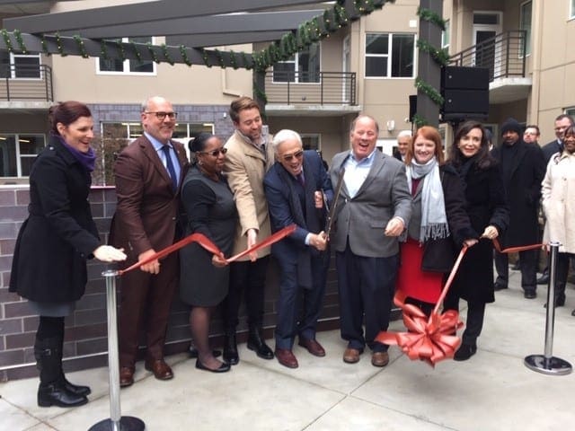 People celebrating an opening of a new business with ribbon cutting